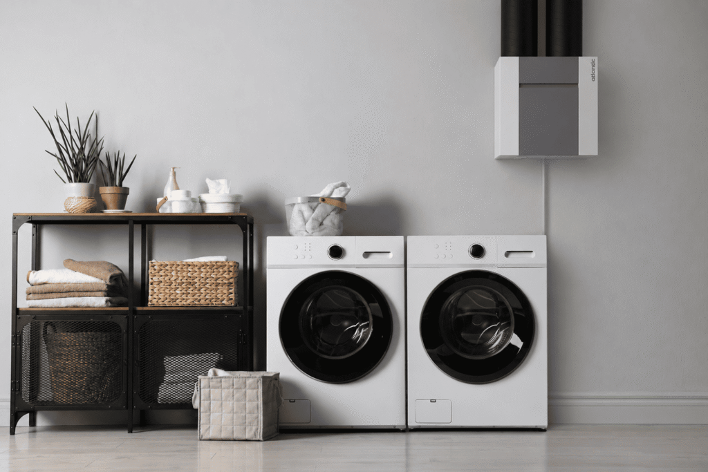 Caisson de VMC double flux installé dans une buanderie au-dessus du lave-linge