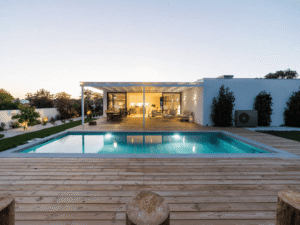 Unité extérieure de pompe à chaleur air-eau installée contre la façade d’une villa moderne avec piscine